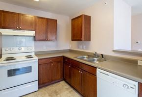 Concord apartment for rent - A kitchen with a white stove and wooden cabinets.