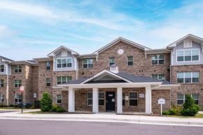 Henrico apartment for rent - A large brick building with a covered entrance and a circular window above the door at Bickerstaff Crossing Apartments, Henrico, VA, 23231
