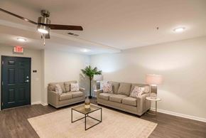 Henrico apartment for rent - A living room with two couches, a coffee table, and a ceiling fan. at Bickerstaff Crossing Apartments, Virginia, 23231