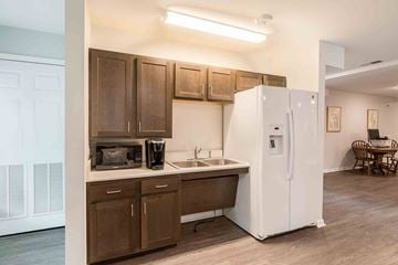 Henrico apartment for rent - A kitchen with brown cabinets and a white refrigerator.