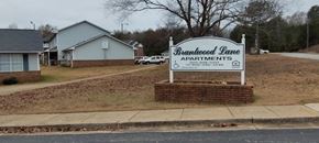 Centreville apartment for rent - A sign for Brannewood Lane Apartments stands in front of a brick wall.