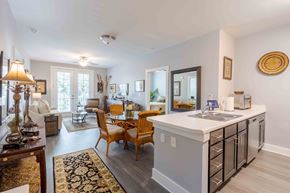 Charleston apartment for rent - A modern kitchen with a white countertop and wooden chairs. at Bulls Creek, South Carolina, 29414