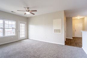 Hendersonville apartment for rent - Open living area with ceiling fan, plush carpet, and view into hallway and entry, providing functional flow at Cedar Terrace Apartments Hendersonville, NC