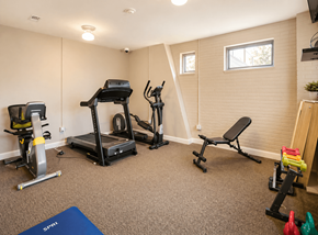Gastonia apartment for rent - A home gym with a treadmill, exercise bike, and weights.
