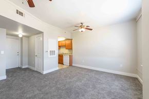 Kinston apartment for rent - A room with a ceiling fan and a kitchen area in the background.at Kinston Hotel Apartments, Kinston, 28501