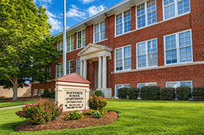 Cramerton apartment for rent - A brick building with a sign that says Maynard School Apartments.