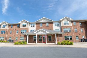 Staunton apartment for rent - A large brick building with a red door in front. at Mountain Laurel III Apartments, Staunton, VA