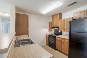Staunton apartment for rent - A kitchen with black appliances and wooden cabinets.