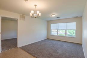 Staunton apartment for rent - A room with a carpeted floor and a chandelier hanging from the ceiling. at Mountain Laurel III Apartments, Staunton, VA