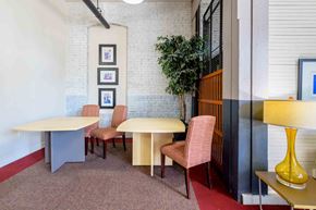 Kinston apartment for rent - A room with a white brick wall and a table with chairs at Nantucket Lofts Apartments, Kinston, NC, 28501