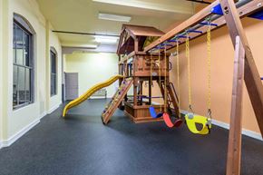 Kinston apartment for rent - A play area with a slide, swings, and a jungle gym at Nantucket Lofts Apartments, North Carolina