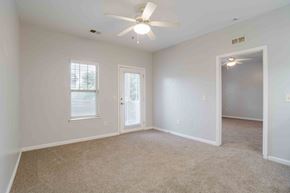 Greenville apartment for rent - A room with a ceiling fan and carpeted floor.