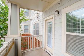 Greenville apartment for rent - A balcony with a white door and a window with blinds.