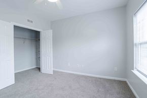 Greenville apartment for rent - A room with a carpeted floor and a ceiling fan.