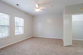 Greenville apartment for rent - A room with a ceiling fan and carpeted floor.