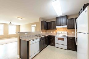 Rolesville apartment for rent - A kitchen with a white refrigerator, a white stove, and a white dishwasher at The Grande at Granite Falls LLC Apartments, North Carolina, 27571