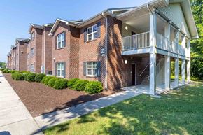 Chesapeake apartment for rent - A red brick apartment building with a white balcony on the second floor. at The Shire Apartments, Chesapeake, Virginia