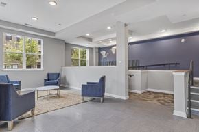Sterling apartment for rent - Lobby with blue chairs and a reception desk at Heronview, Sterling, VA 20166