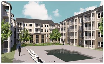 Ladson apartment for rent - A person walks on a pathway in front of apartment buildings.