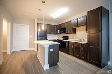 Sterling apartment for rent - A kitchen with dark brown cabinets and a white island.