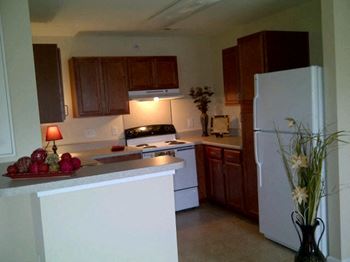 A kitchen with a white refrigerator and wooden cabinets
