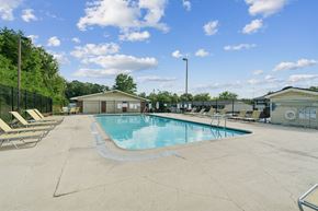 Madison apartment for rent - A large outdoor swimming pool surrounded by a fence and lounge chairs.