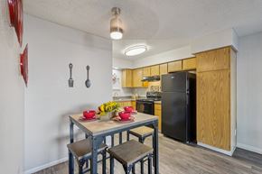 Glendale apartment for rent - A kitchen with a table and chairs in the foreground and a refrigerator in the background.