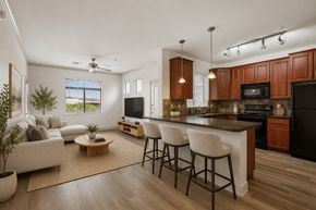 Phoenix apartment for rent - A modern kitchen with dark wood cabinets and a black refrigerator.