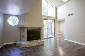 San Antonio apartment for rent - A modern living room with a fireplace and a round window.