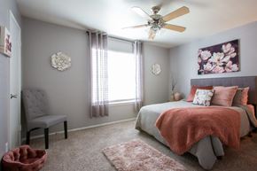 San Antonio apartment for rent - A bedroom with a bed, chair, and a ceiling fan.