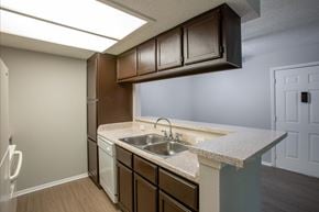 Austin apartment for rent - A kitchen with brown cabinets and a white sink.