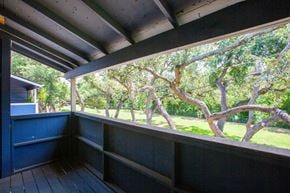 Austin apartment for rent - A balcony with a view of trees and a building.