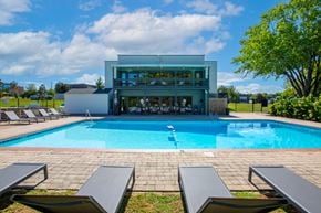 Hendersonville apartment for rent - A swimming pool with lounge chairs and a building in the background.