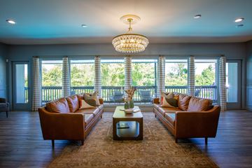 Hendersonville apartment for rent - A living room with brown leather couches and a chandelier.