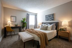 Hendersonville apartment for rent - A bedroom with a bed, desk, chair, and two lamps.