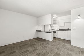 Tucson apartment for rent - A kitchen with white cabinets and a wooden floor.