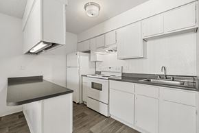 Tucson apartment for rent - A white kitchen with a black counter top.