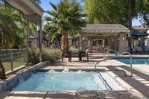Goodyear apartment for rent - A pool with a waterfall and a hot tub in a backyard.