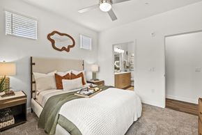 Marana apartment for rent - A bedroom with a bed, nightstand, and a ceiling fan.