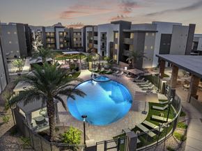Marana apartment for rent - A swimming pool surrounded by palm trees and lounge chairs in a residential area.