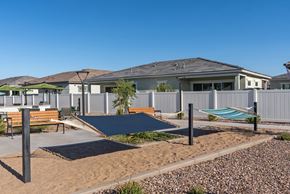 Goodyear apartment for rent - A playground area with a slide and a bench in front of a row of houses.