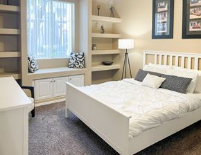 Avondale apartment for rent - A white bed with a white comforter and pillows in a bedroom with a window.