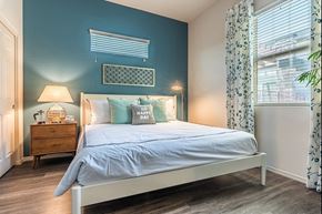 Tucson apartment for rent - A bedroom with a bed, nightstand, and window.