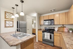 Surprise apartment for rent - A kitchen with a black stove top oven and a granite counter top.