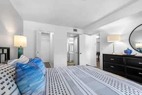 Pompano Beach apartment for rent - A bedroom with a bed covered in a blue and white striped comforter.