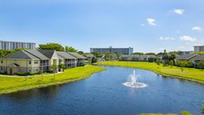 Pompano Beach apartment for rent - A fountain in the middle of a lake surrounded by buildings.