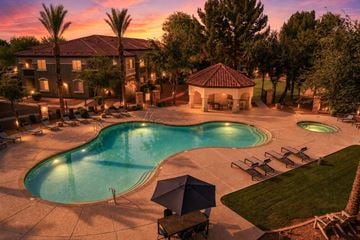 Avondale apartment for rent - A large outdoor swimming pool surrounded by lounge chairs and umbrellas.