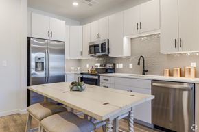 Scottsdale apartment for rent - A modern kitchen with a white table and stainless steel appliances.