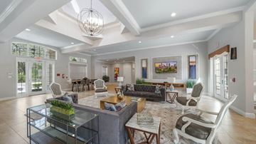 Tampa apartment for rent - A spacious living room with a glass coffee table and a chandelier hanging from the ceiling.