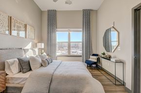 Lone Tree apartment for rent - A bedroom with a large bed and a view of the city.
